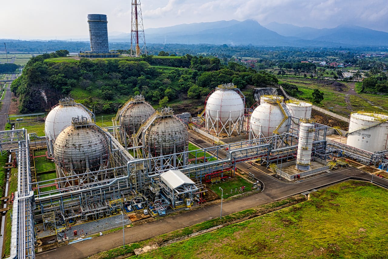 Aerial shot of a power plant with storage tanks in lush Banten, Indonesia offers an impressive scale.